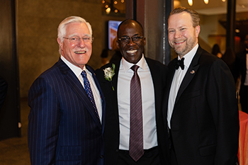 three people in business suits at an event