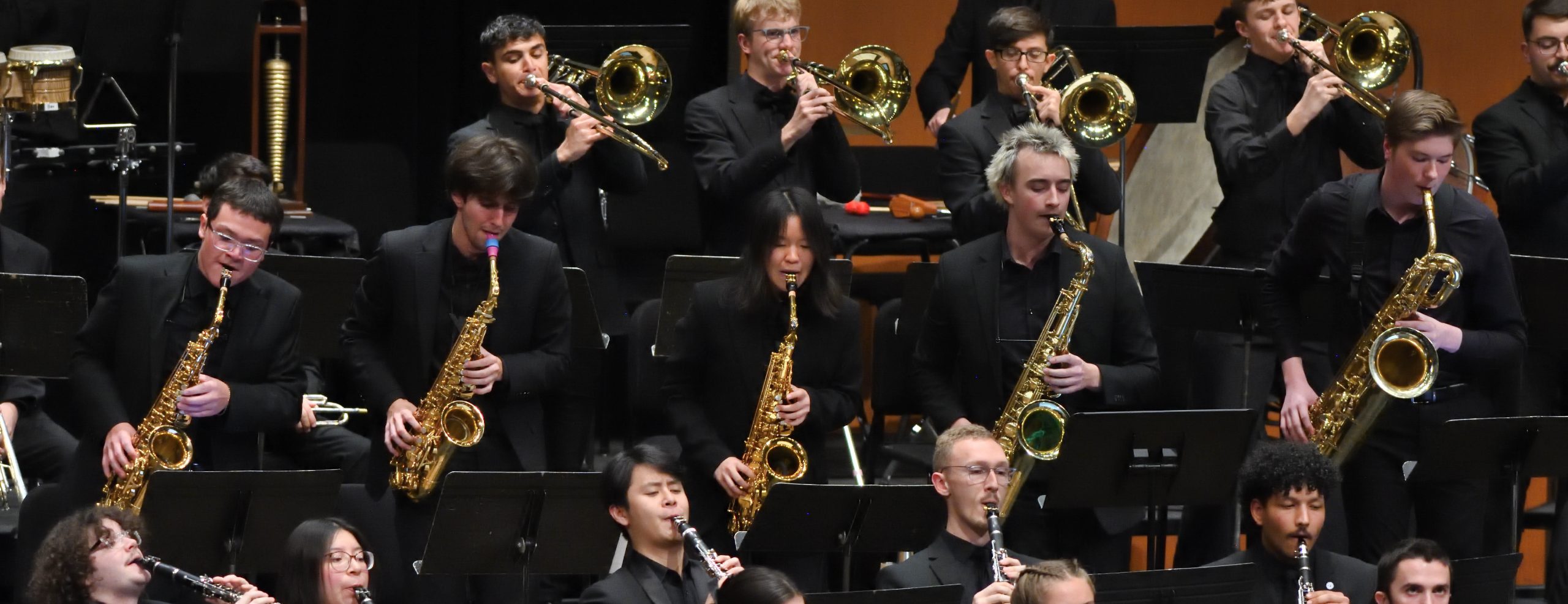 MSU Saxophone, Trombone and Woodwind students playing their instruments on stage.