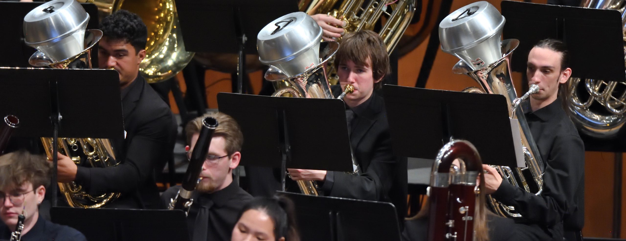 Close up of MSU Euphonium players performing on stage in front of music stands.
