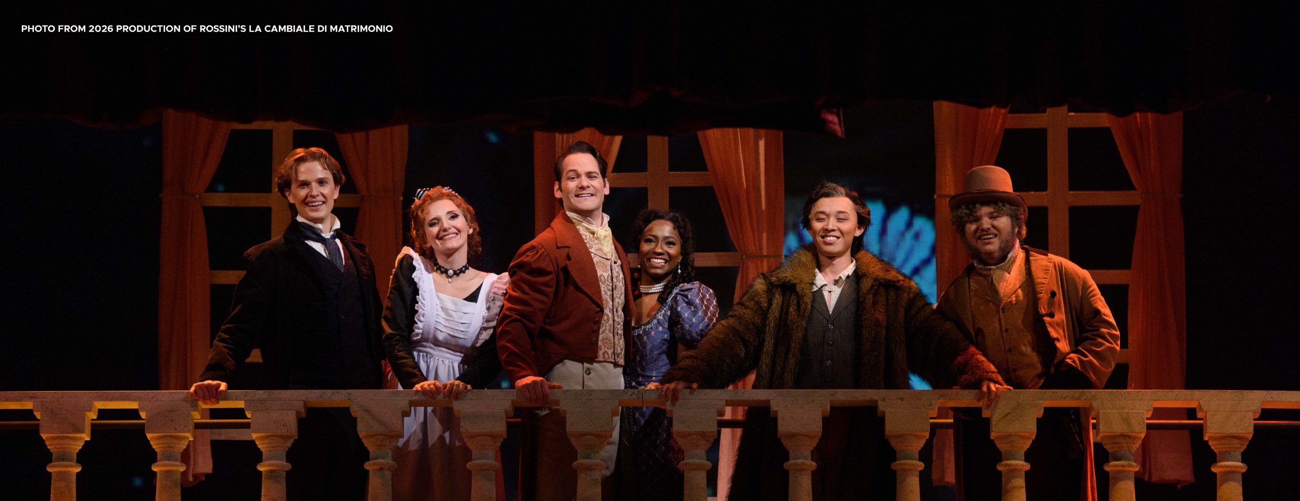Image from MSU's 2026 production of Rossini's La cambiale di matrimonio. Image shows 6 people in costume looking over a balcony.