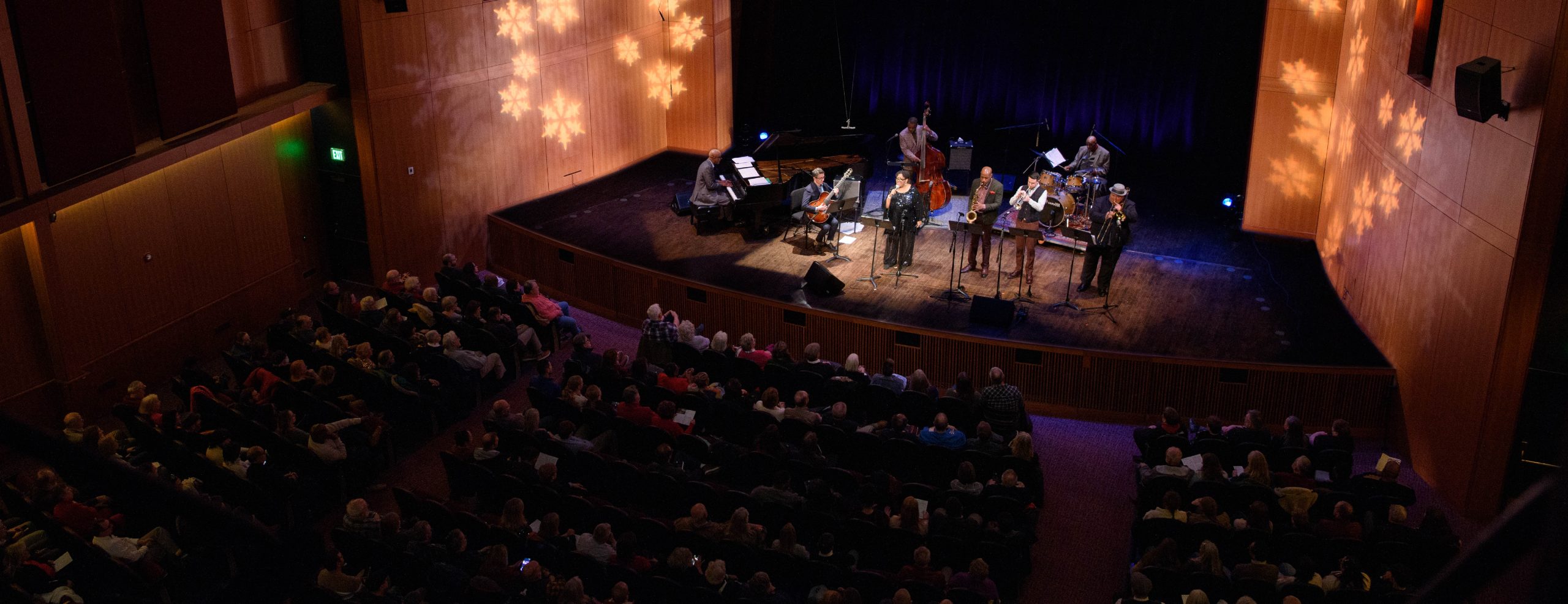 Wide image showing MSU Jazz professors performing on stage in front of audience in Farichild Theatre.