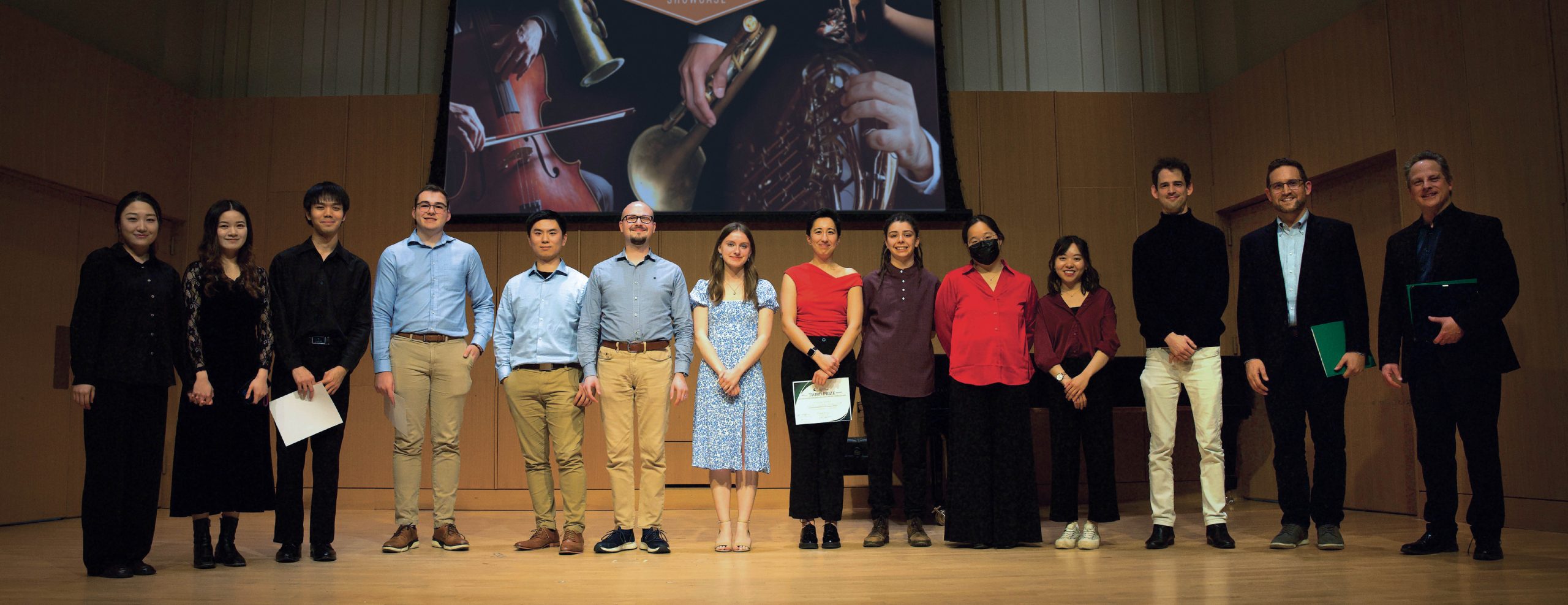 MSU Student Musicians Standing on stage. There is a screen behind them with a collage of instruments.