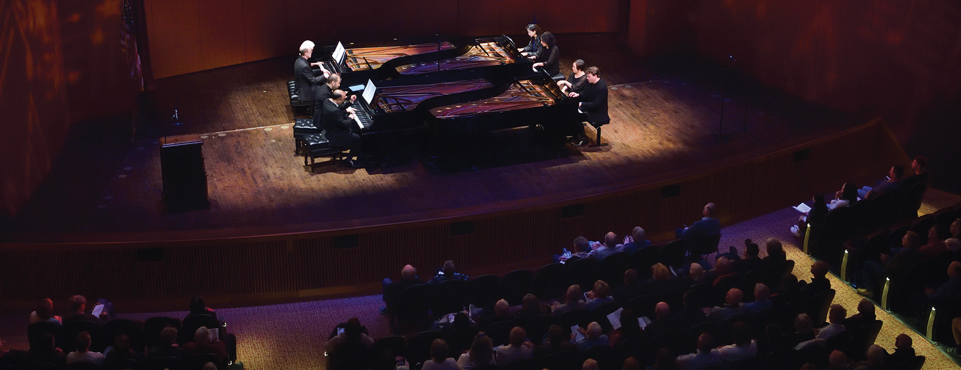 Fairchild theatre stage with four grand pianos and eight pianists performing together
