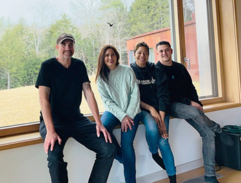 Four people sit inside on a window ledge