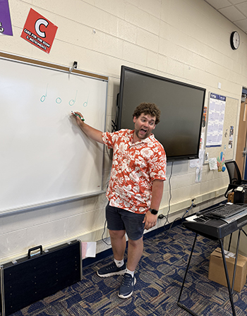 person teaching at a white board in a classroom