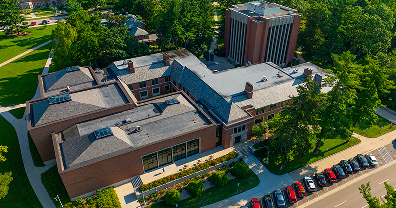 drone view of two buildings with cars parked out front on a street