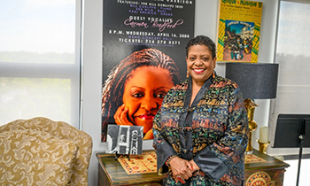 a person stands in front of a promotional poster featuring the same person
