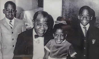 black and white image of an older person surrounded by three children