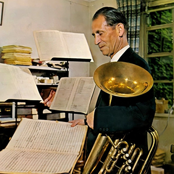 person in office with music pages and brass instrument