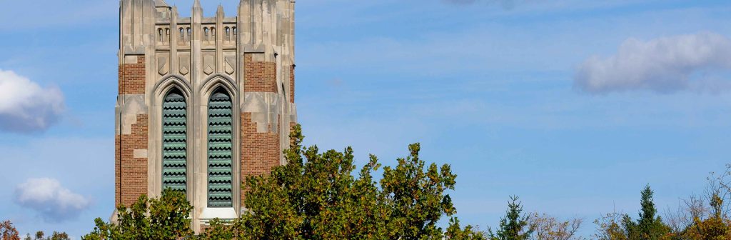 blue sky with top of large brick and cement tower