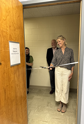 a person cuts a ribbon across an doorway into a room